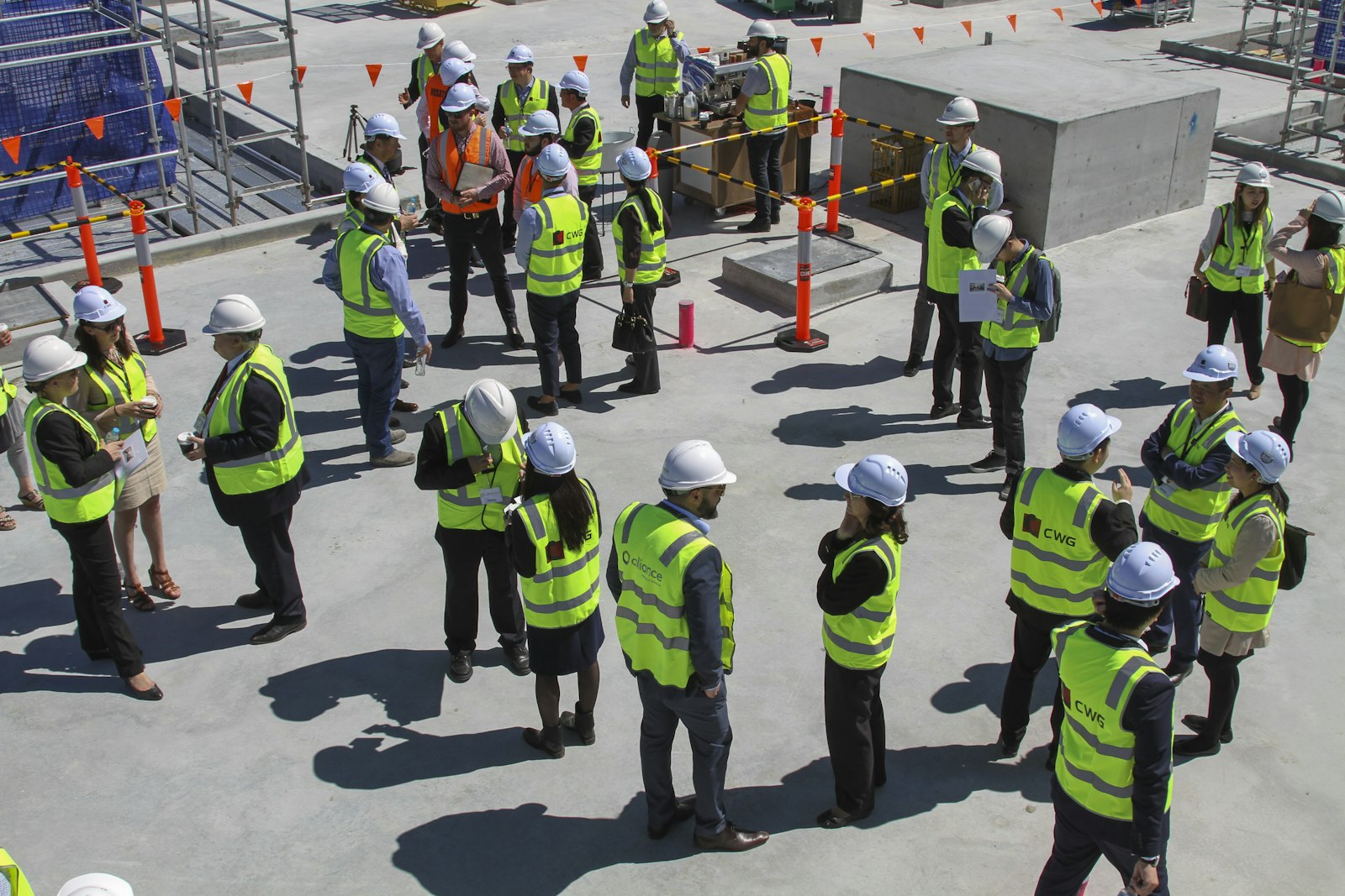 Equipa com capacetes e coletes numa sessão de segurança em obra