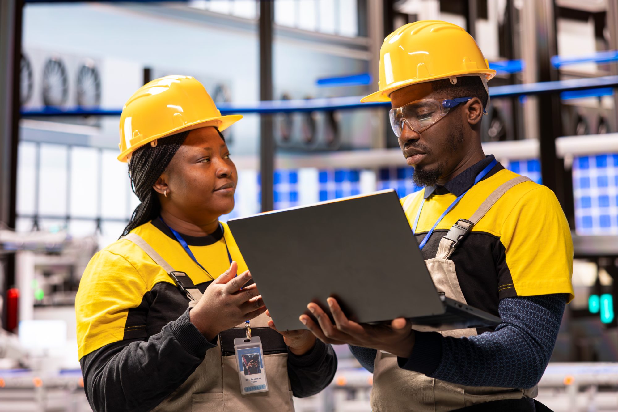 Engenheiros a analisar dados de um sistema industrial num portátil